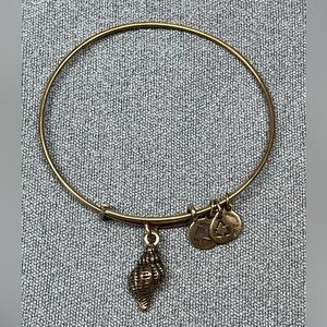 Alex and Ani gold tone bangle bracelet with seashell charm.